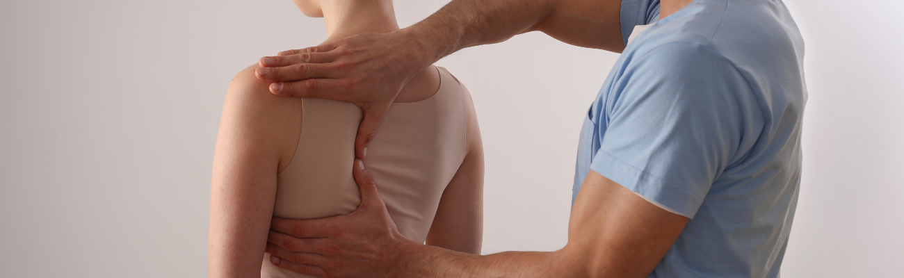 Massage therapist touching woman's back